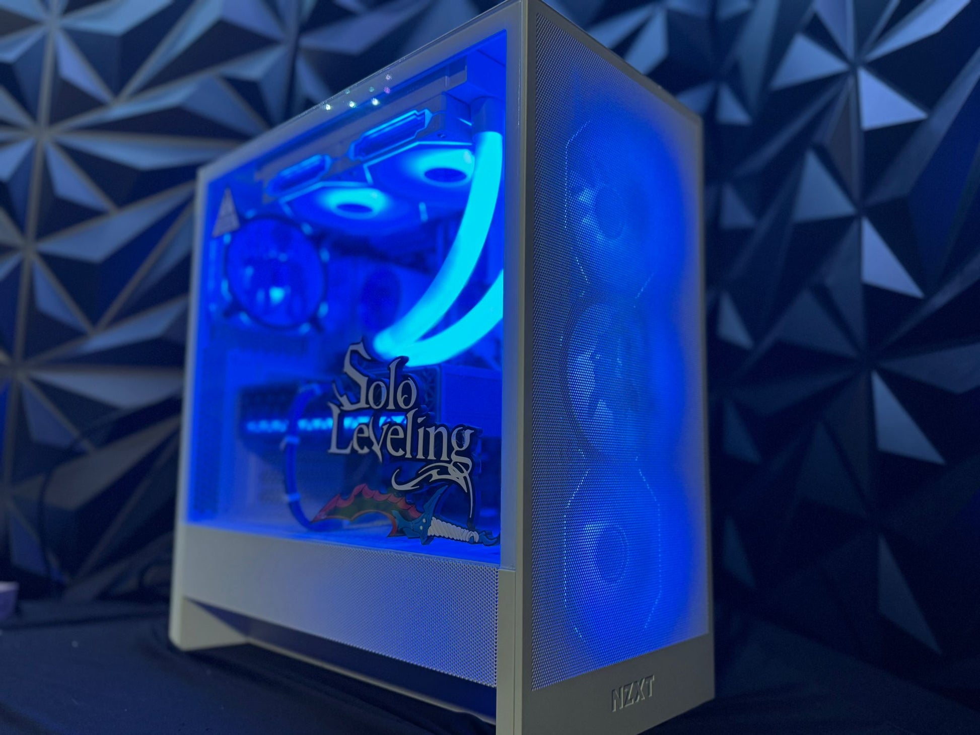 Computer case with blue LED lighting and 'Solo Leveling' branding on a geometric patterned background.